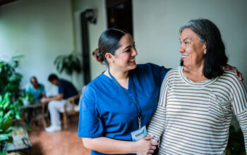 Home caregiver talking to a senior woman at nursing home